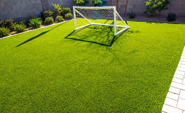 Backyard with artificial turf grass, small soccer goal, and plants. -artificial turf grass